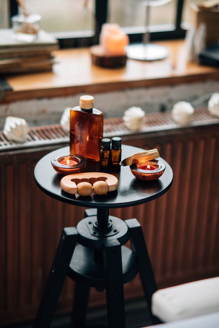 Aromatherapy oils and Palo Santo for relaxation in a serene indoor massage room.